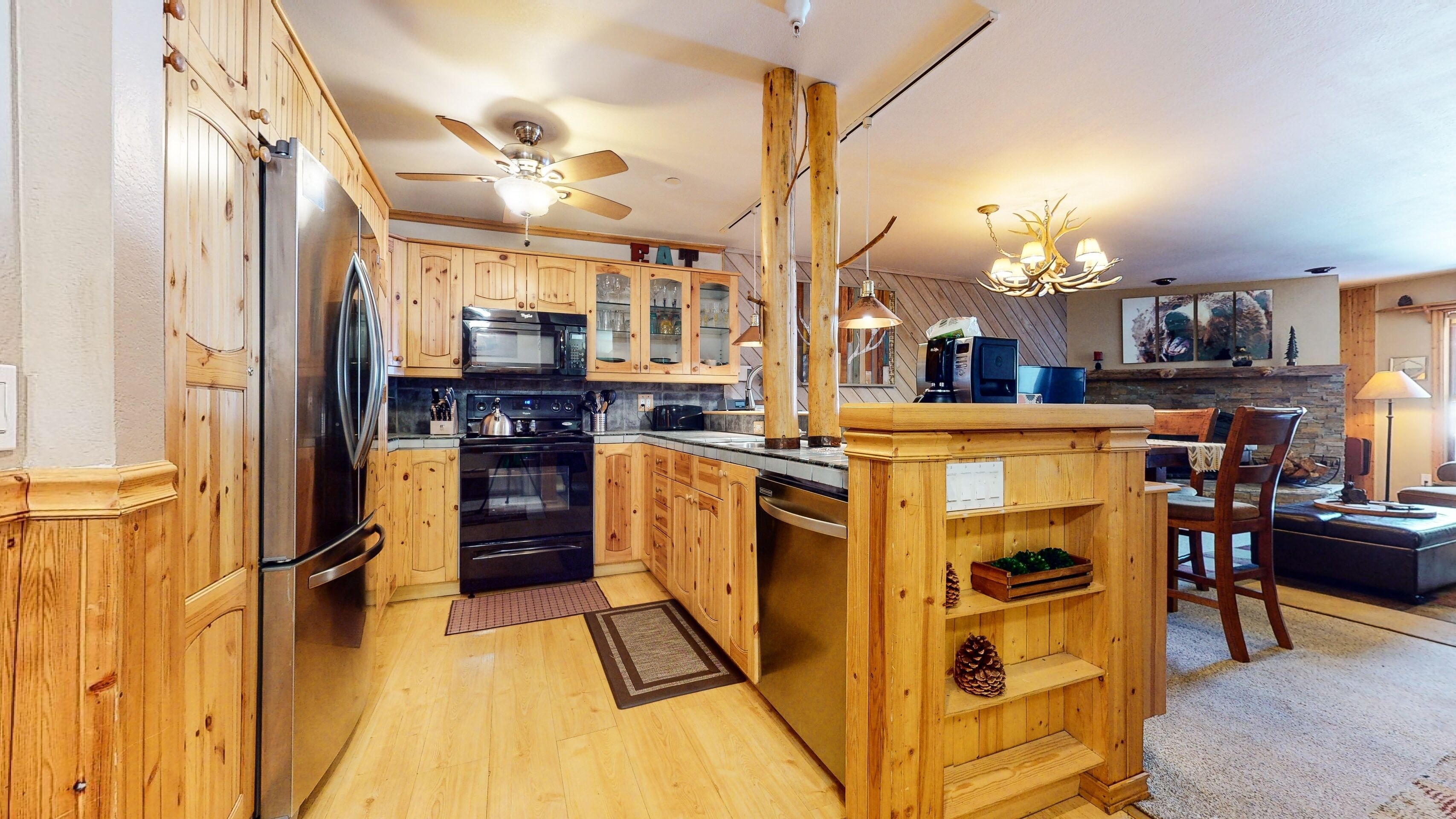 A kitchen with wooden cabinets, a refrigerator, stove, microwave, and a dining area with a table and chairs.