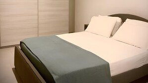 Un dormitorio con cama, mesita de noche y armario.