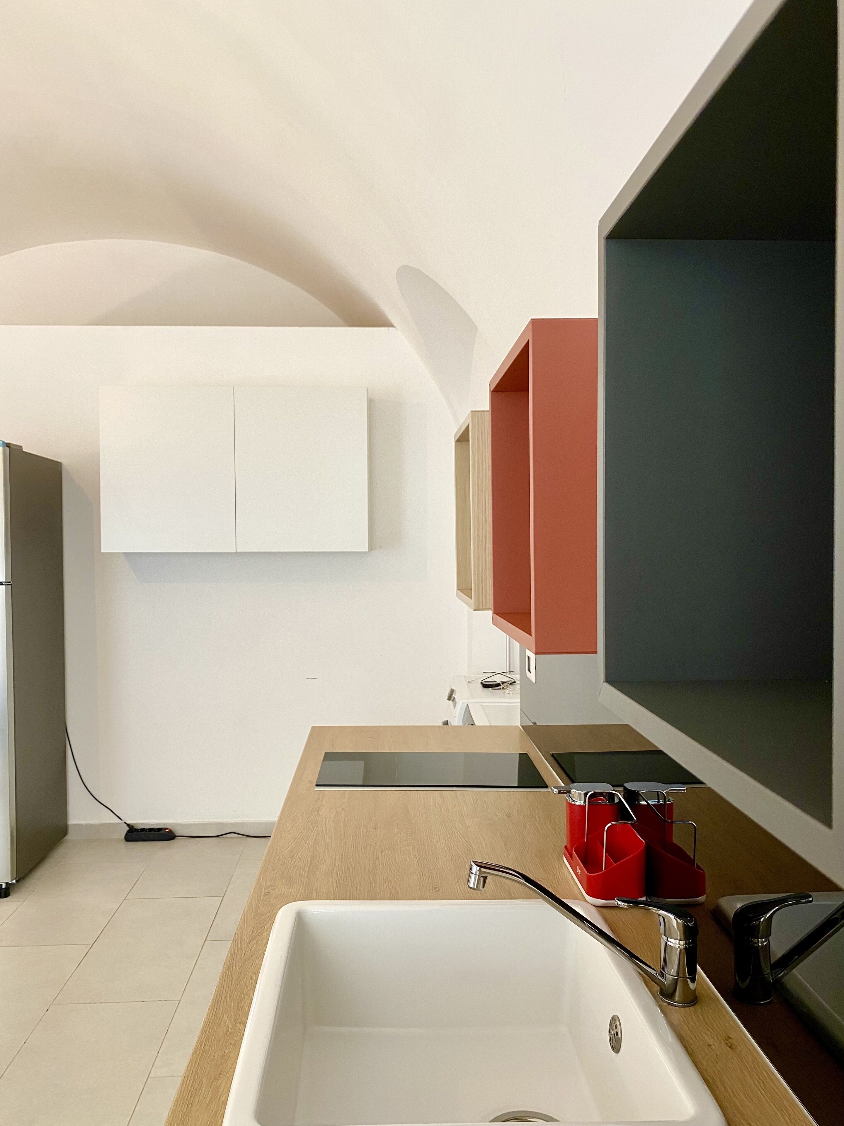 Eine moderne Küche mit einer weißen Spüle, einer Holz Arbeitsplatte und einem eingebauten Backofen.