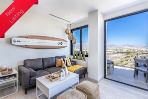 Relax in a spacious living area with a sofa, coffee table, and side table, featuring a scenic desert view.