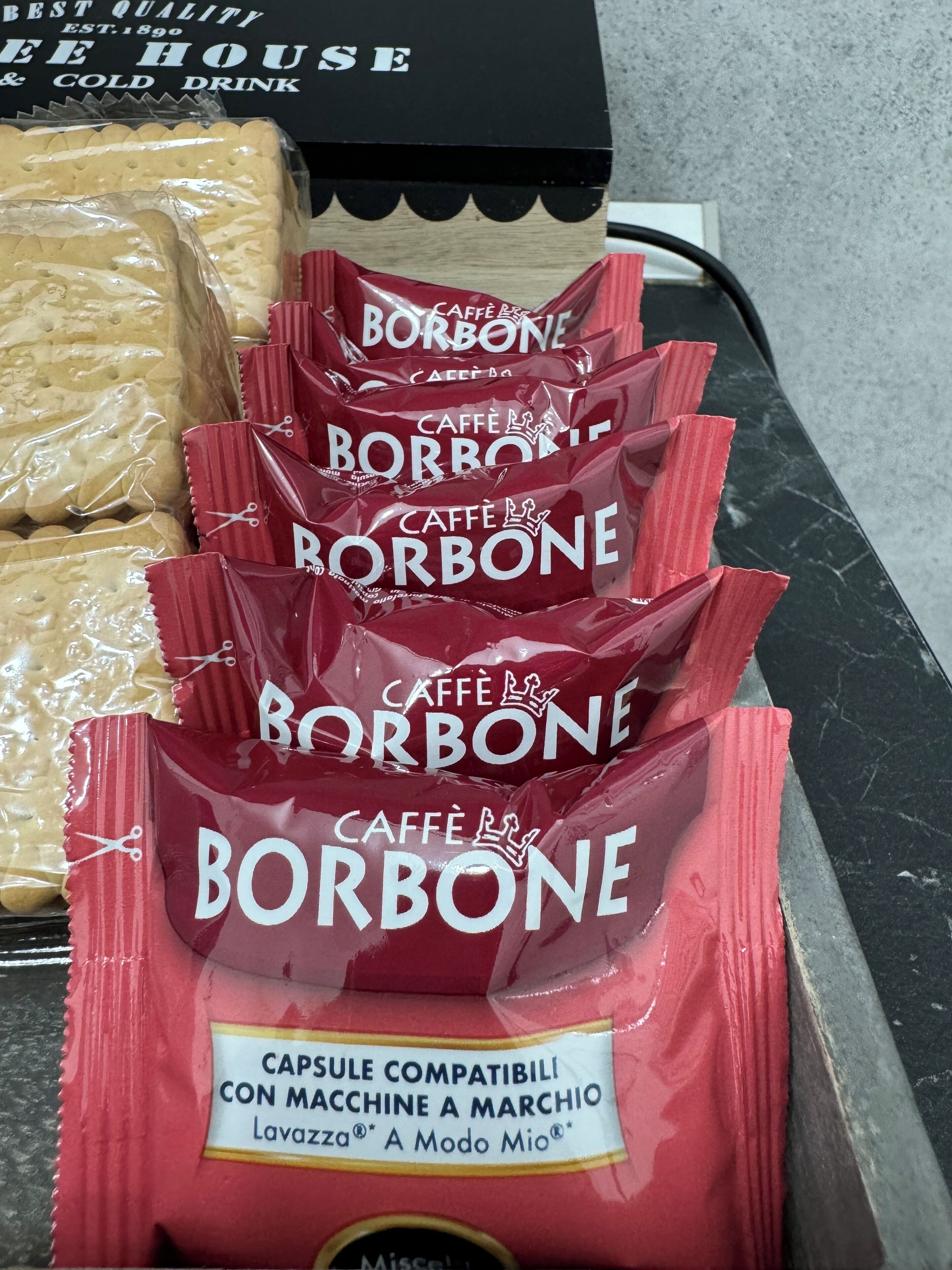 Exposição de cápsulas de café Borbone com etiqueta que indica compatibilidade com uma máquina de café específica.