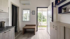 Et moderne køkken med en køkkenbar, et spiseområde med udsigt og en dør til et udendørs område.