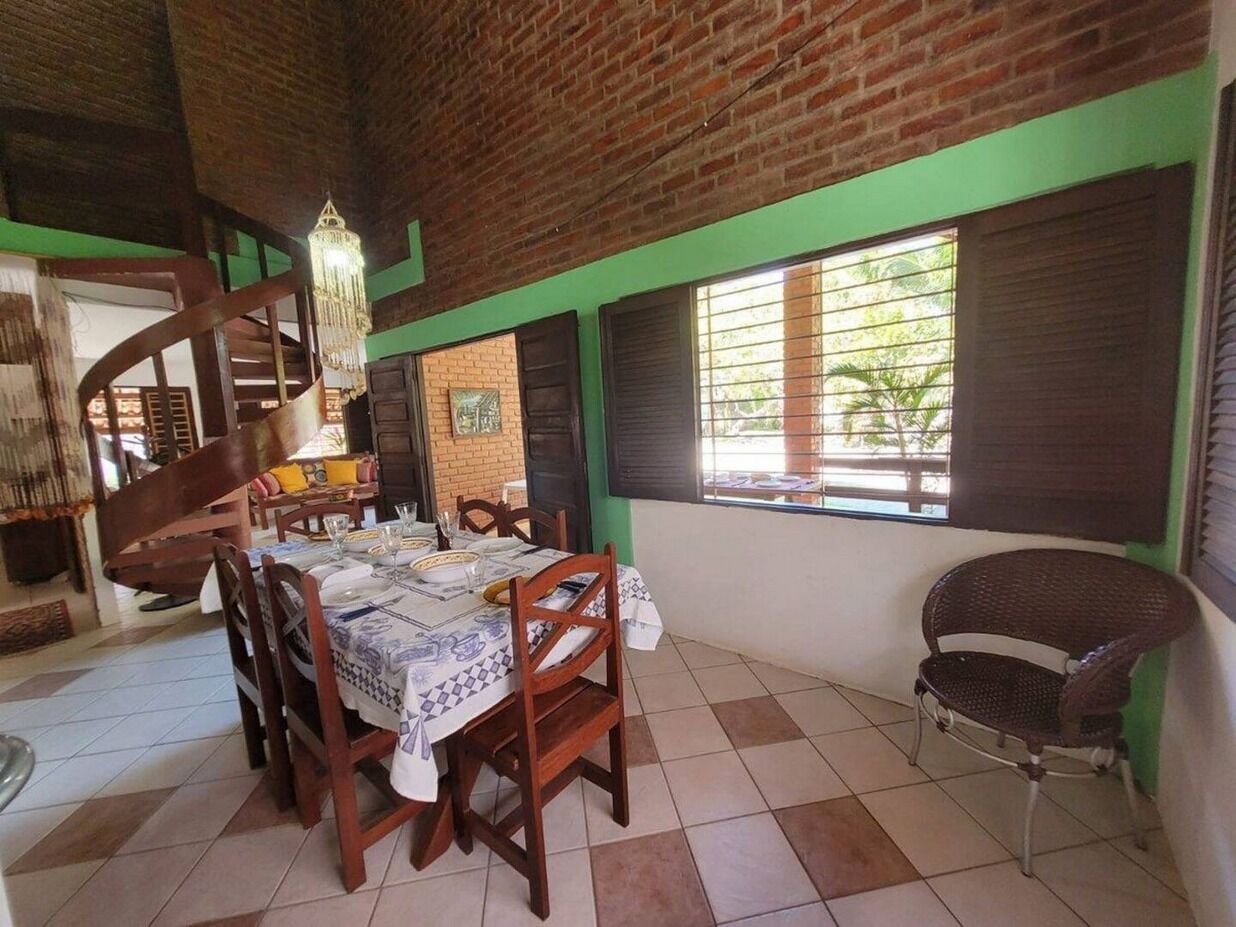 A dining area with a brick ceiling, a staircase, and a window with blinds.
