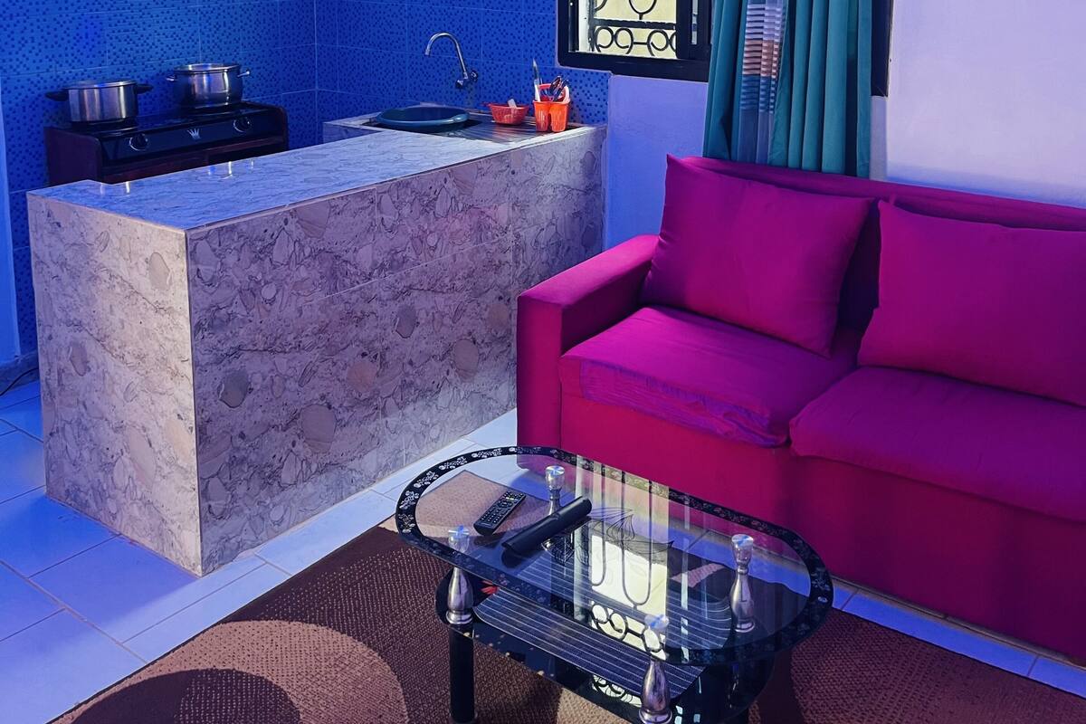 A compact living space with a kitchen area, a sofa, and a coffee table.