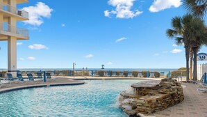 A pool area with lounge chairs and a view of the beach. - Stunning Oceanfront Condo! Sleeps 8, Modern Appliances, Majestic (Panama City Beach)