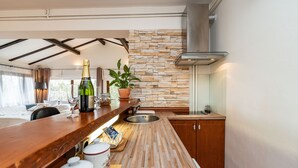 Eine moderne Küche mit Wandverkleidung aus Stein, einer Holz Arbeitsplatte und einer integrierten Spüle.