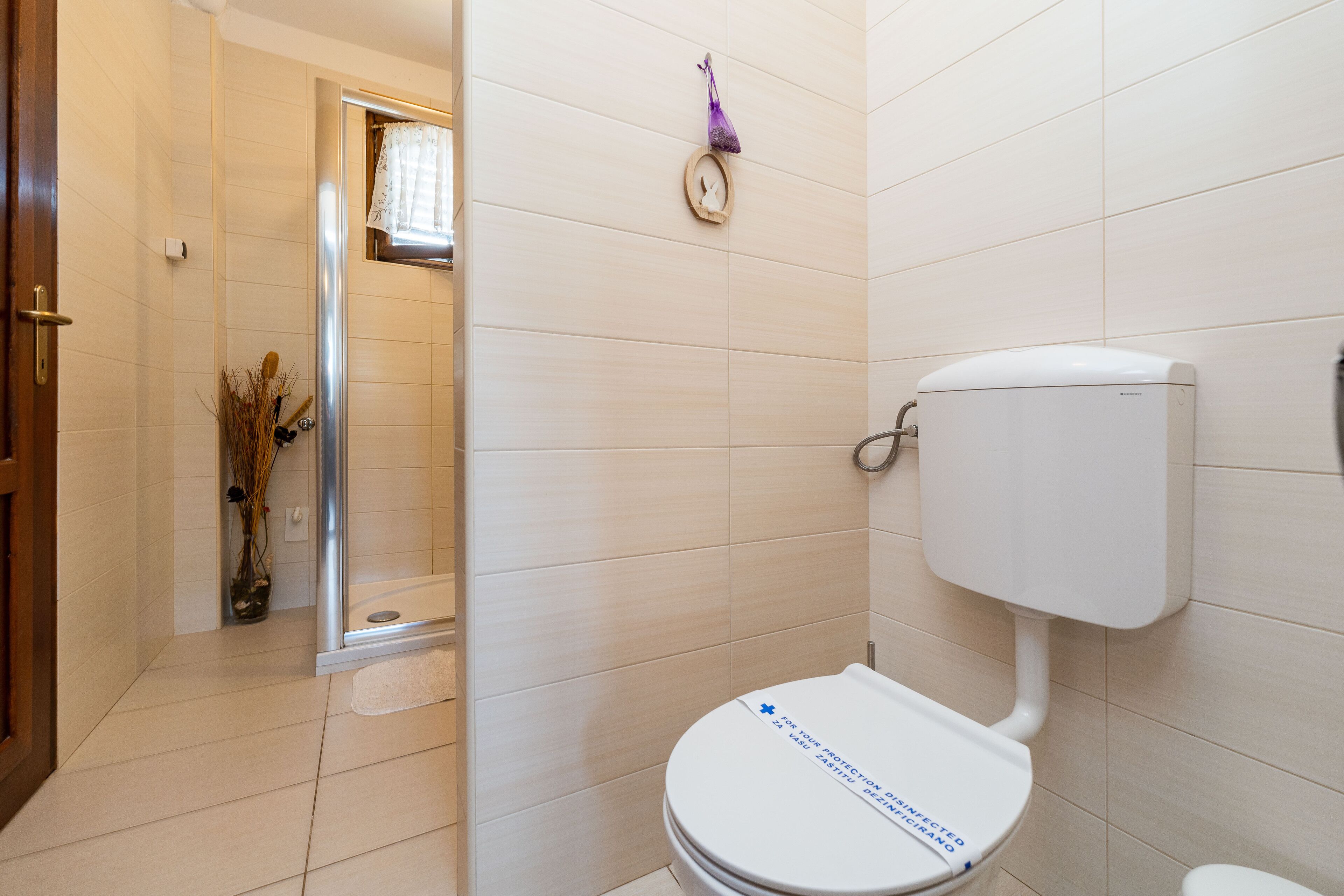 A bathroom with a toilet, a shower, and a sink.