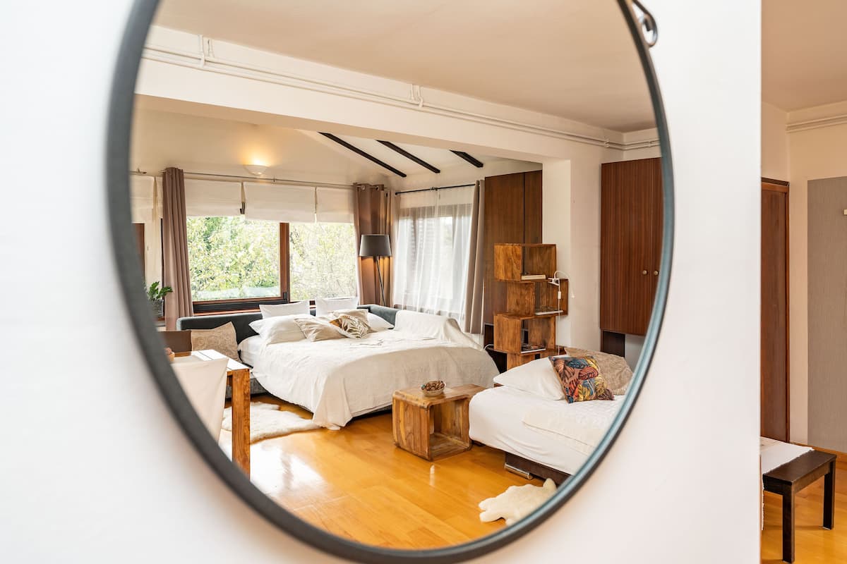 Ein Schlafzimmer mit einem großen Bett, einem Nachttisch, einem Holzbeistelltisch und einem Kleiderschrank.
