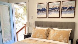 Un dormitorio con una cama grande, cabecera de madera y tres cuadros en la pared.