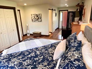 Un dormitorio con una cama grande, un cabecero de madera y una mesita de noche.