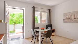 Une chambre moderne avec une table à manger, des chaises, un lit et un tableau au mur.