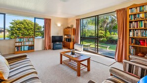 A spacious living room with a large bookshelf, a television, and a comfortable seating area.