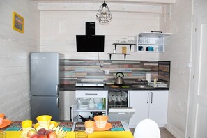 Enjoy cooking in this well-equipped kitchen with a range, refrigerator, and dining area.