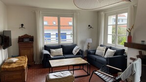 A living room with two sofas, a coffee table, a wooden cabinet, and a TV. - Le Cottage, Jolie Villa à 3 Minutes de la mer ! (Ambleteuse)