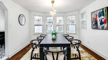 A dining area with a rectangular table, six chairs, and a chandelier.