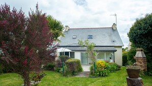 A house with a sloped roof, a front door, and a small porch. - Le Gîte de Beauport - Proche des plages (Paimpol)