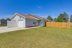 A single-story house with a garage, a wooden fence, and a well-maintained lawn.