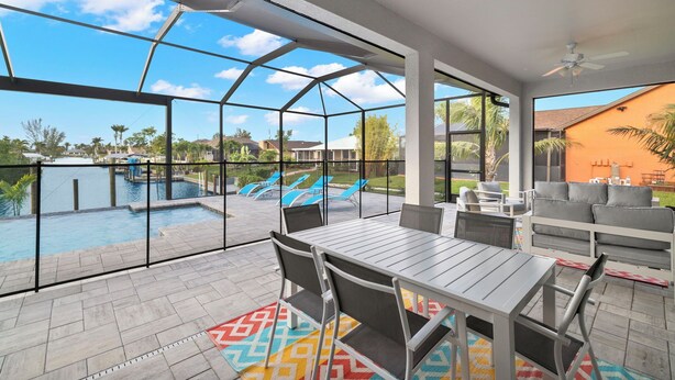 Eine überdachte Terrasse im Freien mit Pool, Sitzbereich und Blick auf die umliegende Wohngegend.