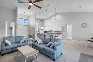 A modern living room with two sofas, a coffee table, and a ceiling fan. - Coastal Cozy Villa by Distinctive Beach Rentals (Cape Coral)