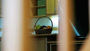 A kitchen with a wicker basket containing bananas, grapes, and an orange on the counter. - Lovely 3-bed Apartment in Skopje (Skopje)