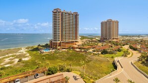 A high-rise hotel with multiple balconies, a pool, and a beach view. - New Listing P5-0906 2B Portofino Island View! (Pensacola Beach)