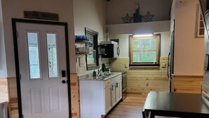 Una cocina amplia con armarios de madera, una isla central y un comedor con mesa y sillas.
