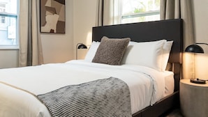 A neatly made bed with a striped throw, a headboard, and two bedside lamps. - La Vie Boheme, Cozy, Minutues to Coconut Grove (Miami)