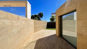 Un espace architectural moderne doté d’une structure en béton, d’un plancher en bois et d’une porte en verre.