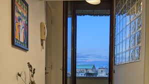 A dining area with a table set for two, a potted plant, and a painting on the wall. - Napoli City Panorama (Naples)
