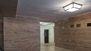 A hallway with marble walls, a tiled floor, and directional signs. - Napoli City Panorama (Naples)