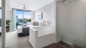 Une chambre moderne avec un grand lit, une table de chevet et une vue sur la ville.
