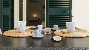 A table set with various cups and a small jar of cookies, placed on woven placemats. - Almond Tree Suite (Ostuni)