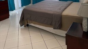 A bedroom with a bed, a dresser, and a nightstand. - Bucket List Stays (Ocho Rios)