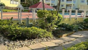A resort with multiple yellow buildings, a pool area, and lush greenery. - Bucket List Stays (Ocho Rios)