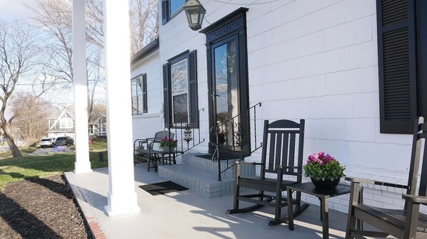 Enjoy the classic charm of this home's inviting porch, complete with a bench and table.