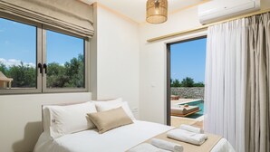 Une chambre d’hôtel avec un lit, une vue sur la piscine et une grande fenêtre.