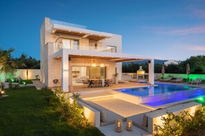 A modern two-story house with a swimming pool, outdoor seating, and a well-lit patio area. - New-build Villa Riza Chania private pool and Roofgarden with jacuzzi (Chania)