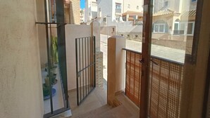 A balcony with a view of neighboring buildings and a gated entrance. - 154 Casa Lelik (Tarifa)