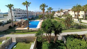 A resort with a swimming pool, palm trees, and modern buildings. - 154 Casa Lelik (Tarifa)