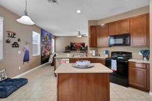Enjoy cooking in this well-equipped kitchen with a central island, microwave, stove, and ample counter space.