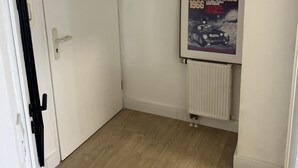 A room with a white door, a radiator, and a framed poster on the wall. - Wunderschöne 1-zimmer Wohnung (Wiesbaden)