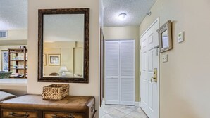 A hallway with a wooden dresser, a mirror, and a white closet. - Outstanding Location | 1BR Haven near the Strip (Las Vegas)
