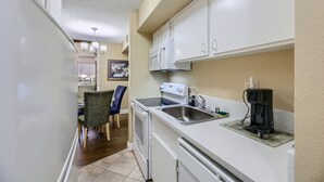 A compact kitchen with white cabinets, a built-in microwave, a coffee maker, and a sink. - Outstanding Location | 1BR Haven near the Strip (Las Vegas)