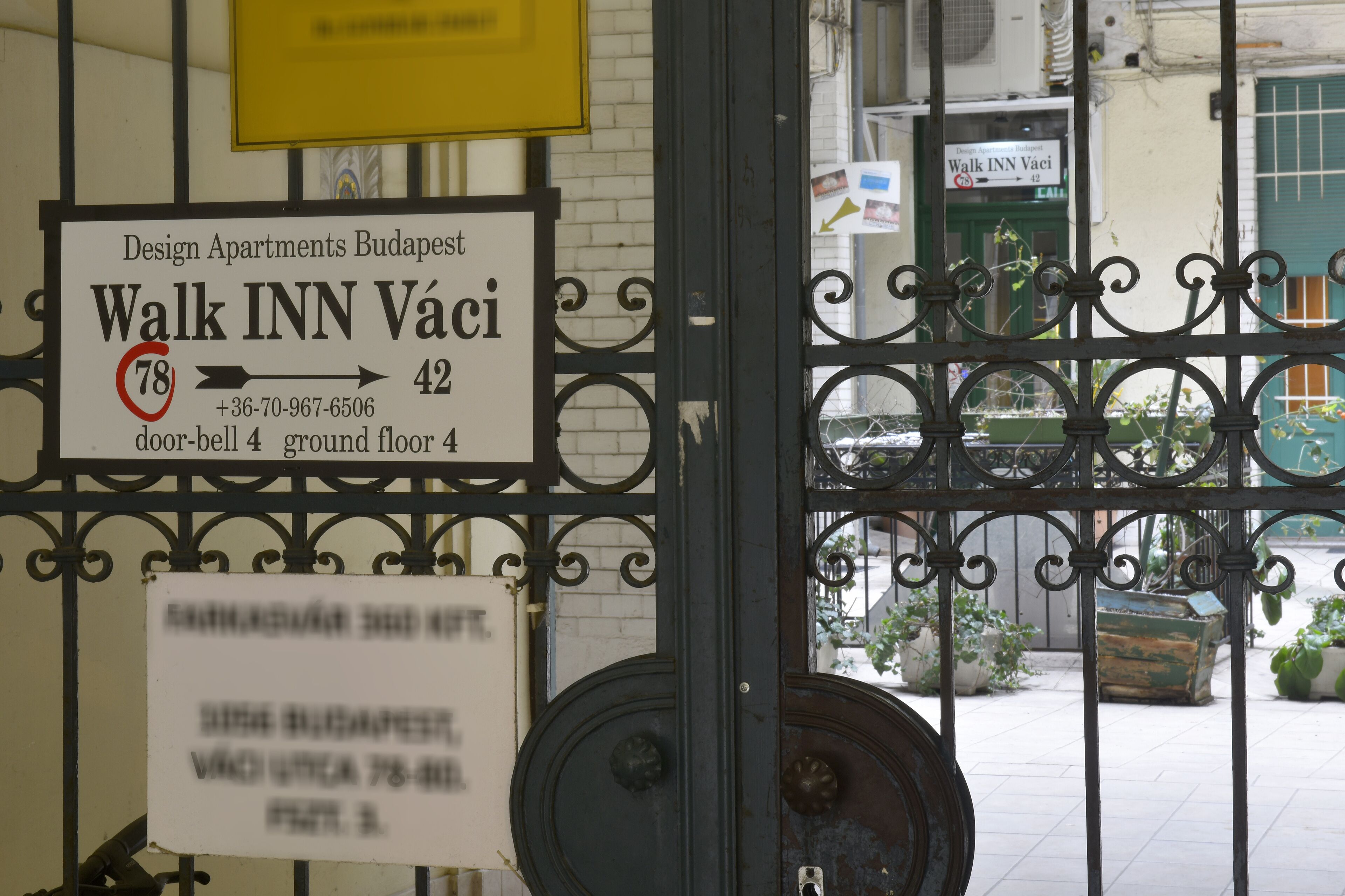 A sign for Design Apartments Budapest, Walk INN Váci, with contact information and location details.