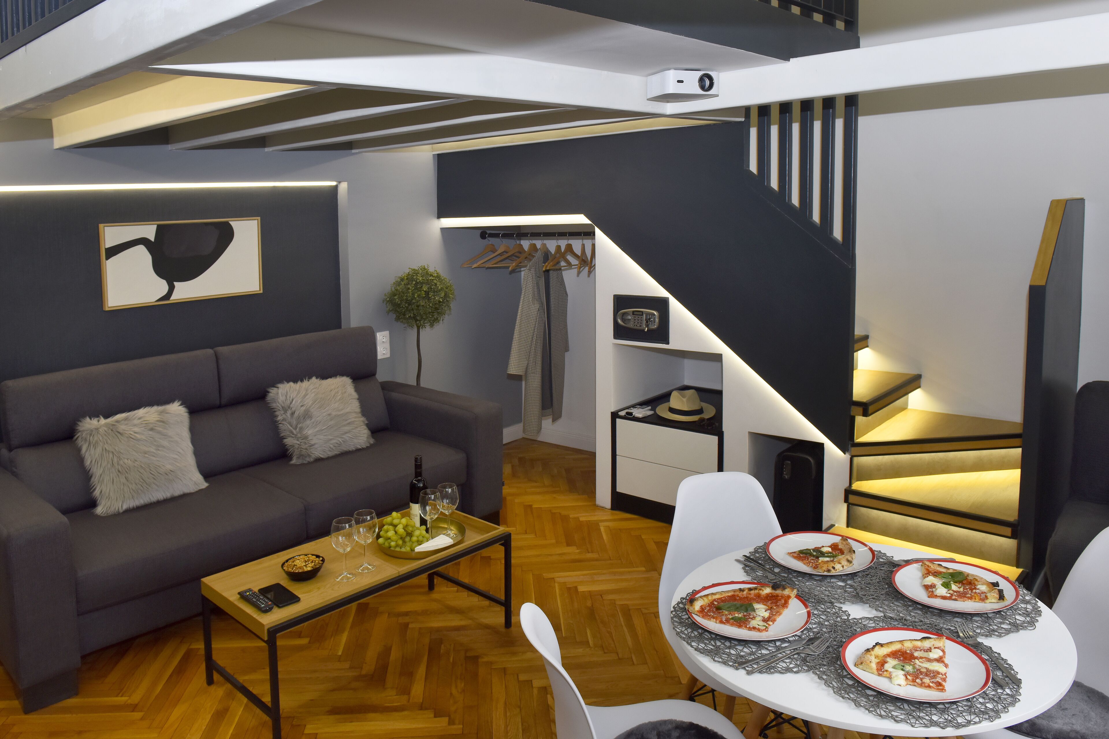 Un salon moderne avec un canapé, une table basse et une table à manger dressée pour un repas.