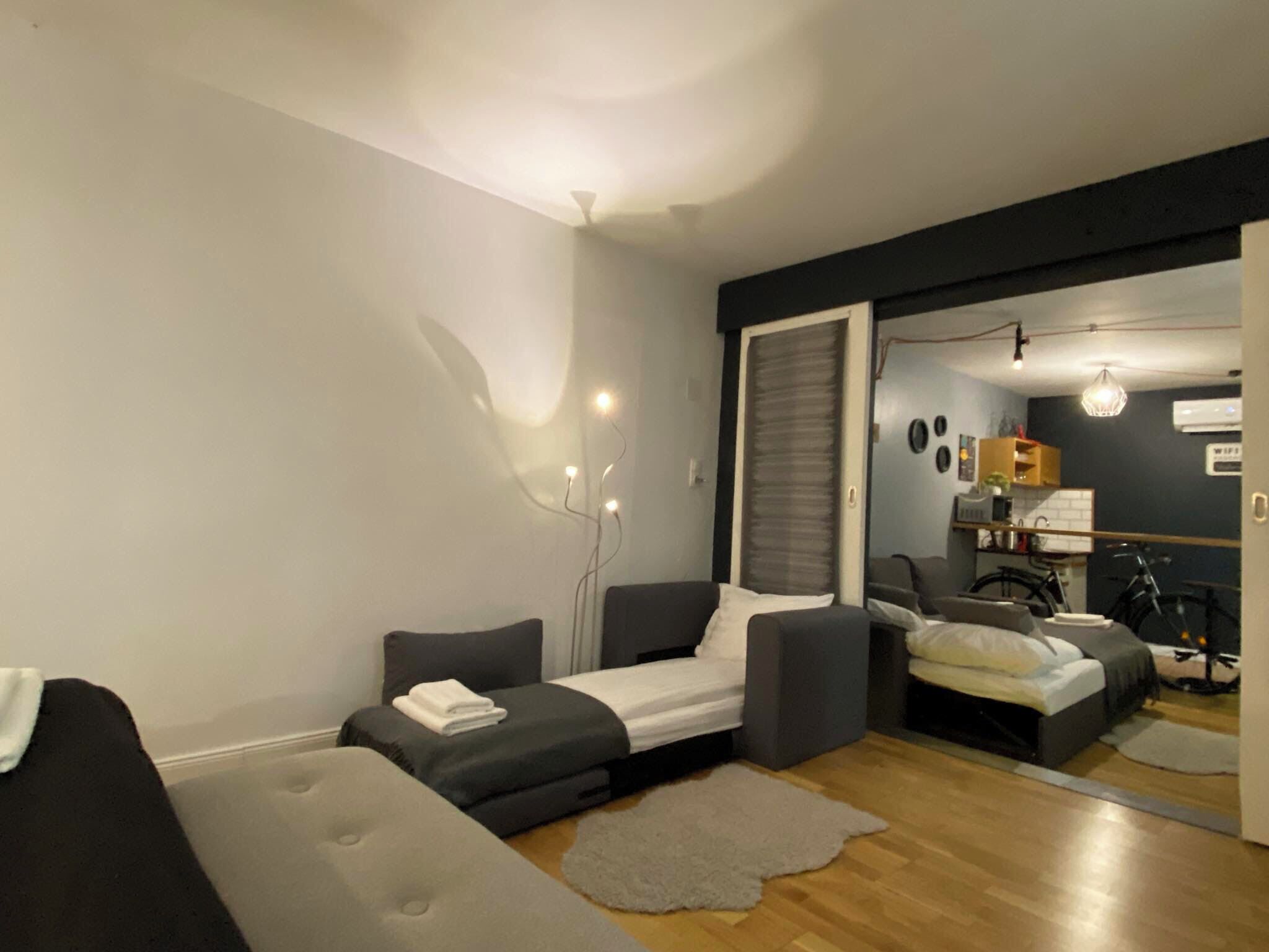 Un salon moderne avec un canapé, un petit lit et un coin repas.