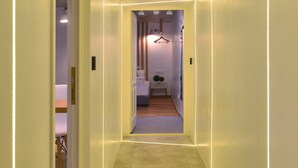 A narrow hallway with a tiled floor and walls lined with recessed lighting. - Walk Inn Váci 78 (Budapest)