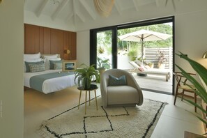 A bedroom with a bed, bedside table, and a potted plant.