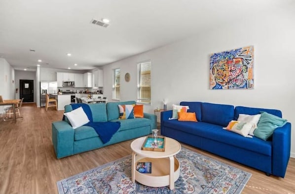 A modern living room with two sofas, a coffee table, and a colorful rug.