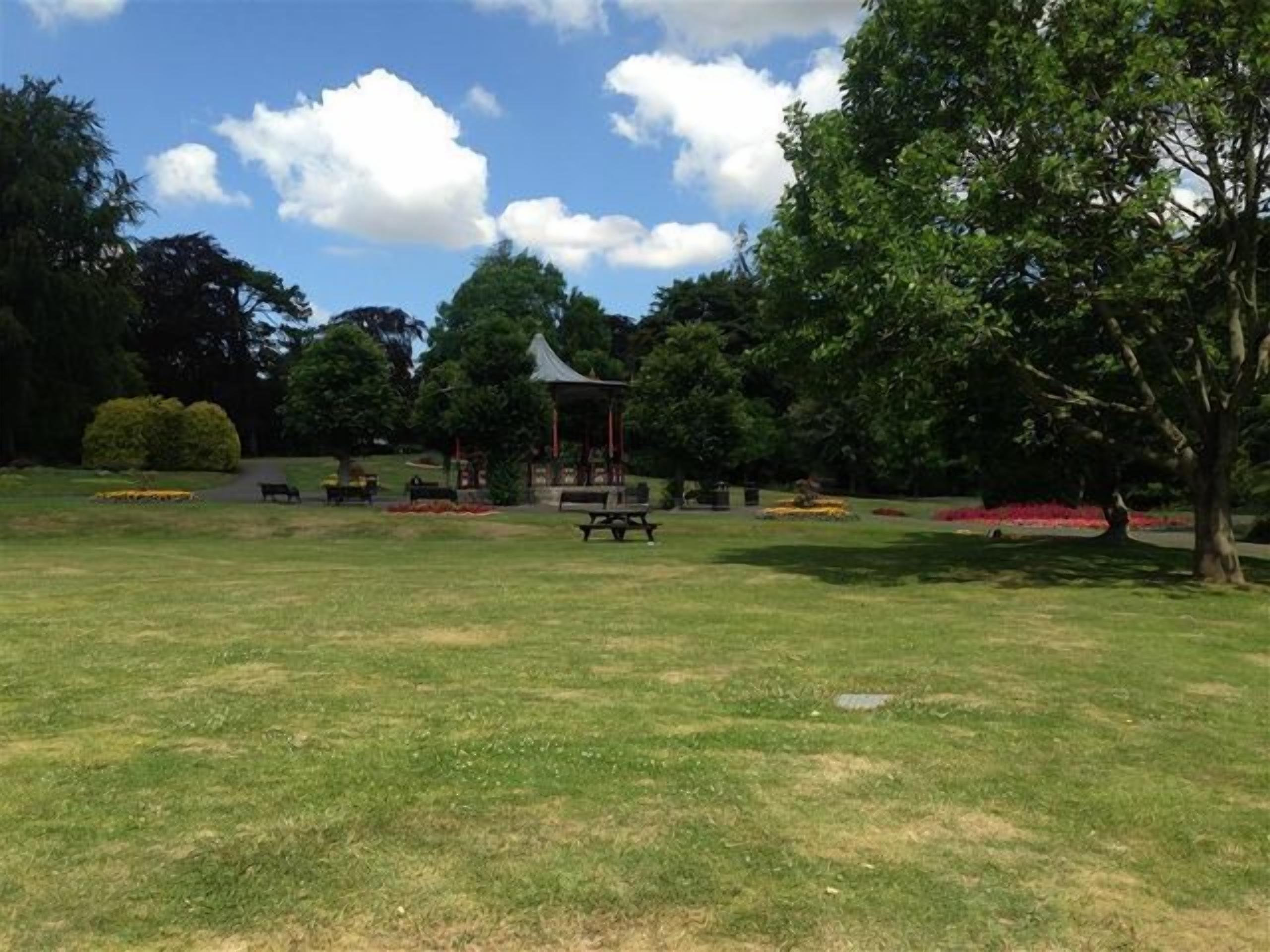 A park with a gazebo, picnic tables, and benches.